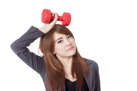 Asian businesswoman hold a dumbbell over her head isolated on white の写真素材