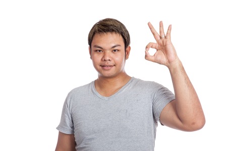 Asian strong man show ok sign look at the camera wear casual dress isolated on white backgroundの写真素材