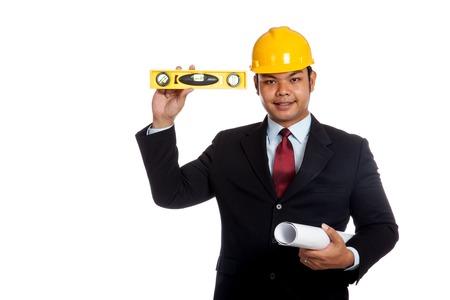 Asian engineer man  hold blue print and level look at camera and smile isolated on whtie backgroundの写真素材
