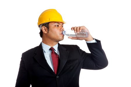 Asian engineer man drink water from a bottle isolated の写真素材