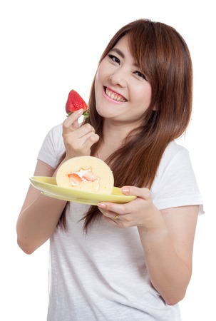 Asian girl smile with strawberry roll cake isolated on white backgroundの写真素材