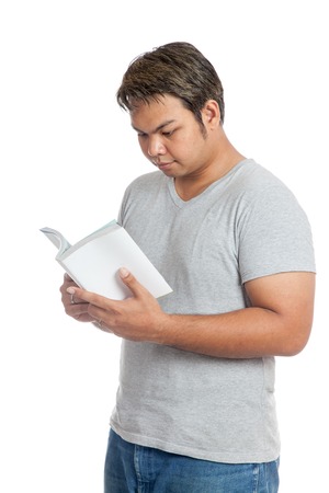 Asian man reading a book isolated on white backgroundの写真素材