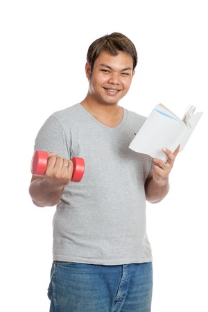 Happy Asian man hold  book and red dumbbell isolated on white backgroundの写真素材