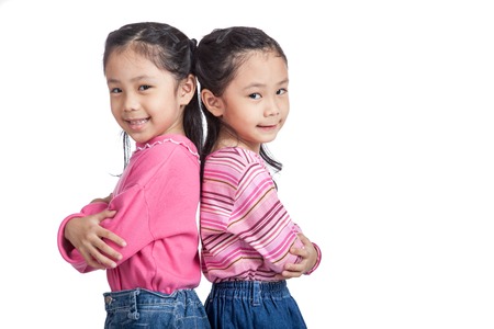 Asian twin sisters fold arms  standing back to backの写真素材
