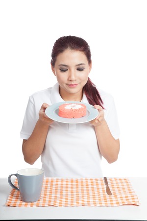 Asian girl smell strawberry cake and smile isolated on white backgroundの写真素材