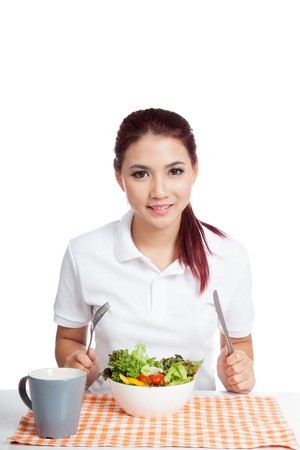Happy Asian girl eat salad isolated on white backgroundの写真素材