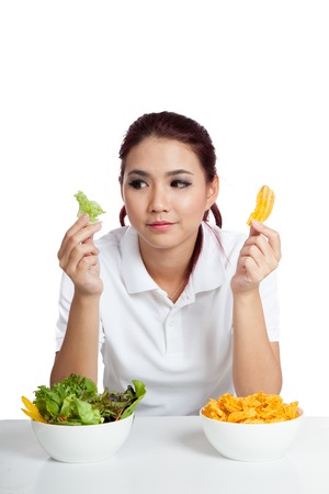 Asian girl with salad and crisps in her hands  isolated on white backgroundの写真素材