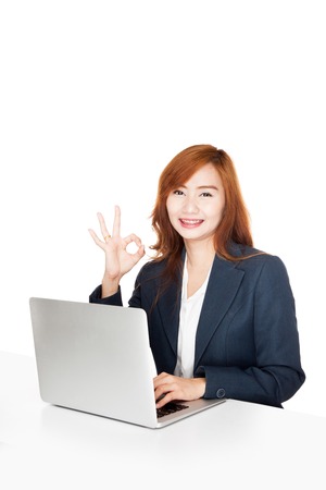 Asian office girl show OK sign with notebook PC  isolated on white backgroundの写真素材