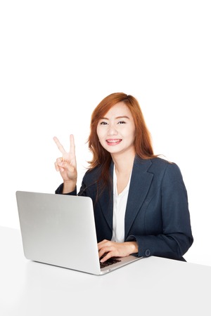 Asian office girl show victory sign with notebook PC  isolated on white backgroundの写真素材