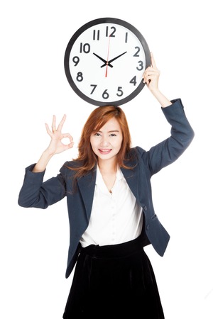 Asian businesswoman show OK sign with clock over head  isolated on white backgroundの写真素材