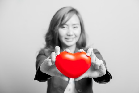 Asian girl show red heart with both hand  focus at the heart on black and whiteの写真素材