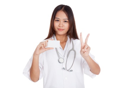 Asian young female doctor show victory sign with blank card  isolated on white backgroundの写真素材