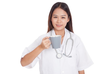 Young Asian female doctor hold a mug and smile  isolated on white backgroundの写真素材