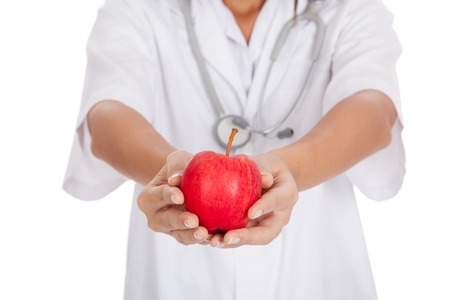Young Asian female doctor show an apple  isolated on white backgroundの写真素材