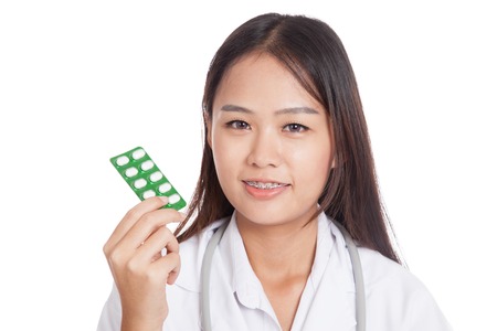 Young Asian female doctor  smile with Blister pack of tablets  isolated on white backgroundの写真素材