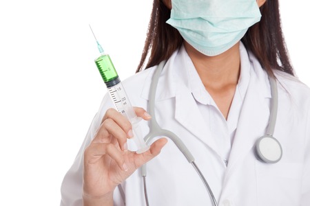 Young Asian female doctor with mask hold syringe  isolated on white backgroundの写真素材