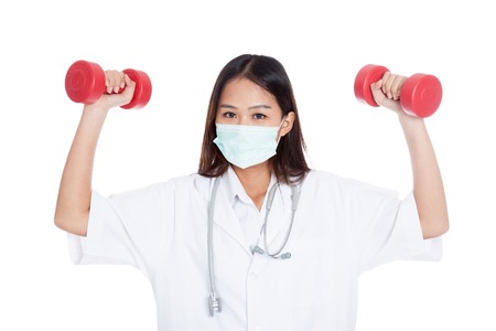 Young Asian female doctor wear mask with dumbbell in both hands isolated on white backgroundの写真素材