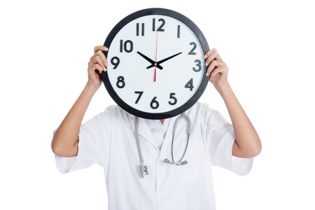 Doctor hold a clock over her face  isolated on white background