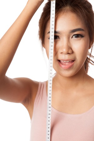 Asian skinny girl with measuring tape  isolated on white の写真素材