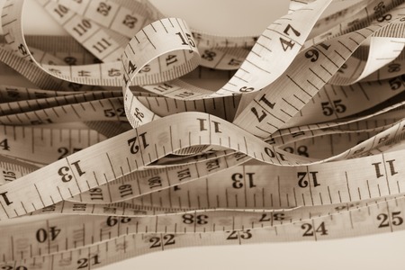 Close up untidy measuring tapes in sepia color