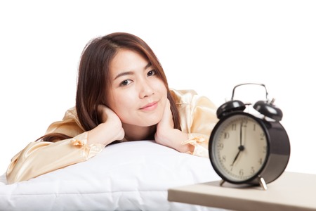 Happy Asian girl  wake up  with alarm clock  isolated on white backgroundの写真素材