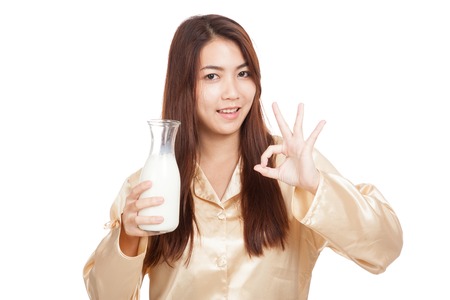 Happy Asian woman show OK drink milk in morning  isolated on white backgroundの写真素材