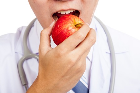 Close up of Asian male doctor eat red appleの写真素材