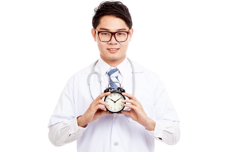 Asian male doctor with a clock  isolated on white background  isolated on white backgroundの写真素材