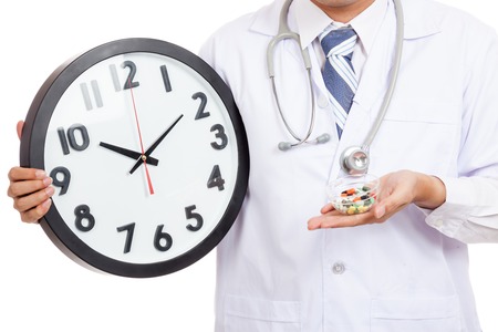Close up of Asian male doctor show a clock and pillsの写真素材