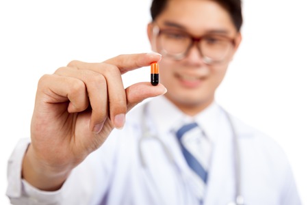 Asian male doctor show a capsule  isolated on white backgroundの写真素材