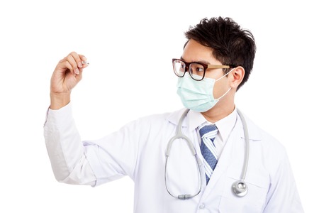 Asian male doctor wear mask look at  thermometer  isolated on white backgroundの写真素材