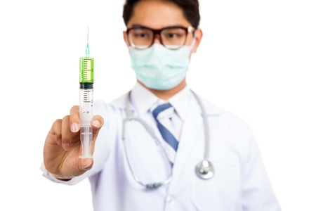 Asian male doctor with syringe focus at syringe isolated on white backgroundの写真素材
