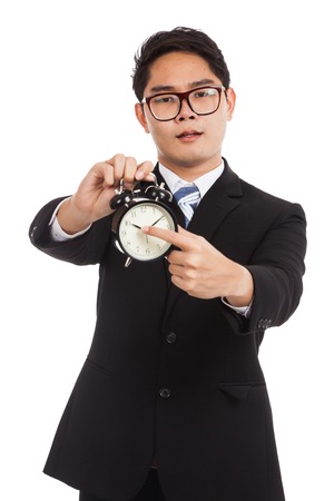 Asian businessman angry point to alarm clock  isolated on white backgroundの写真素材
