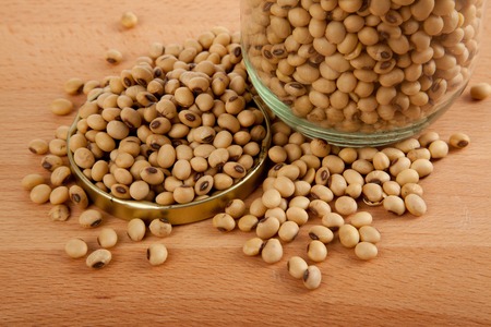 Close up of soybean in a jar with lid off on wood table
