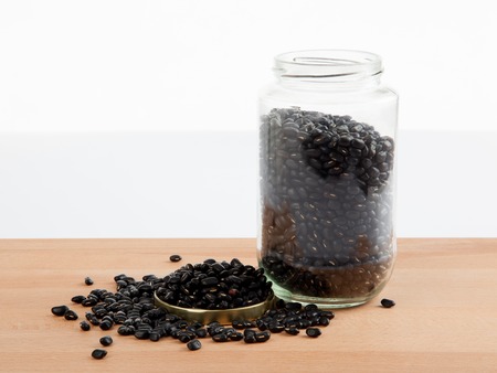 Black beans in a jar on wood table with lid offの写真素材