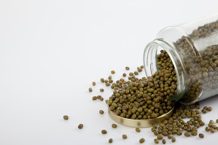 Mung beans in a jar on white  table with lid off on white backgroundの写真素材
