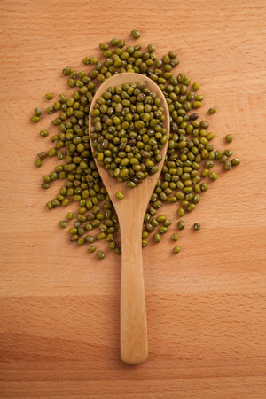 Mung beans with wooden spoon on wood backgroundの写真素材