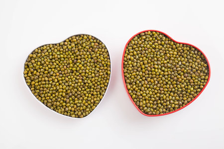 Mung beans  in heart shape box on white backgroundの写真素材