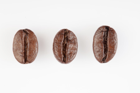Close up of Three roasted coffee beans  on white background