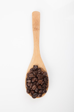 Roasted coffee beans with wooden spoon  on white backgroundの写真素材