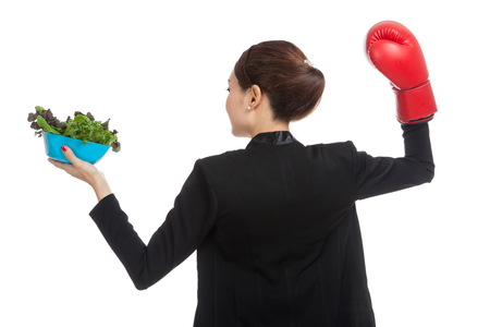 Young Asian business woman with boxing glove and salad  isolated on white backgroundの写真素材