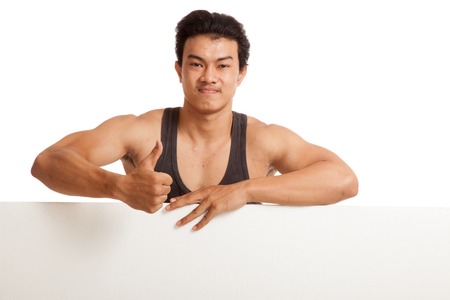 Muscular Asian man thumbs up behind  blank sign  isolated on white backgroundの写真素材