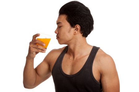 Muscular Asian man drink orange juiceの写真素材