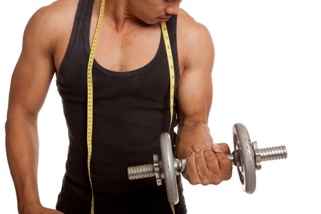 Muscular Asian man with measuring tape and dumbbell  isolated on white backgroundの写真素材