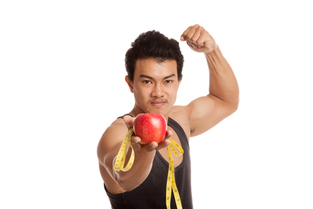 Muscular Asian man flexing biceps with measuring tape and apple  isolated on white backgroundの写真素材