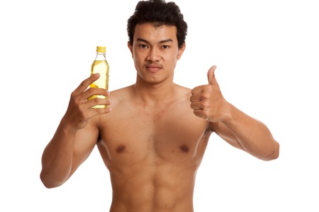 Muscular Asian man thumbs up with electrolyte drink  isolated on white backgroundの写真素材