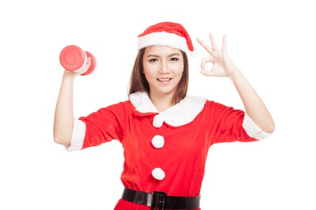 Asian Christmas girl show Ok with Santa Claus clothes and red dumbbell  isolated on white backgroundの写真素材