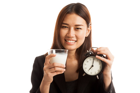 Healthy Asian woman drinking  glass of milk hold clock  isolated on white background.の写真素材