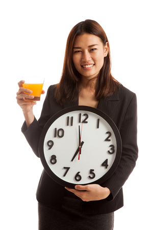 Asian woman with a clock drink orange juice  isolated on white background.の写真素材