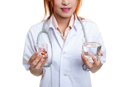 Young Asian female doctor with water and medicine  isolated on white background.の写真素材